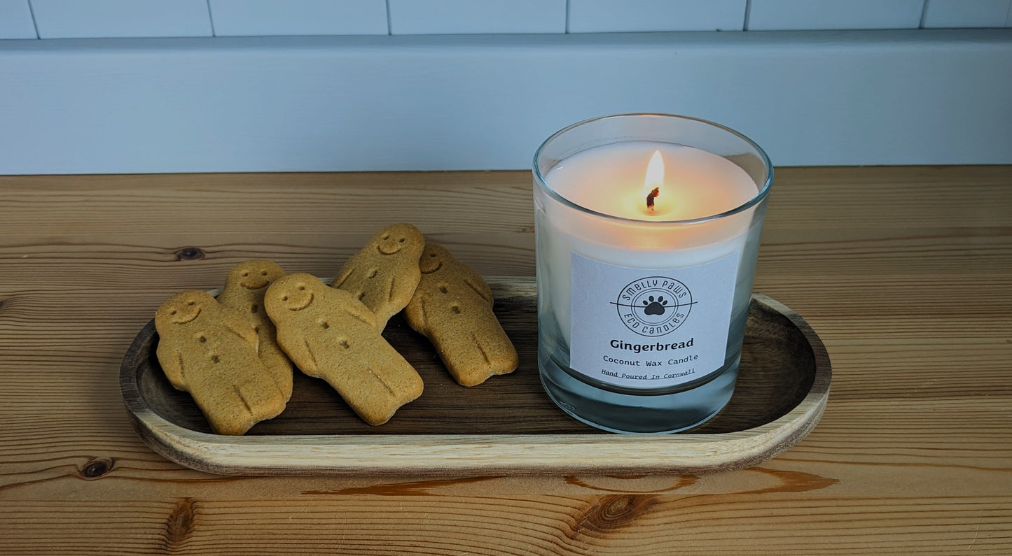 Burning Gingerbread candle sat on wooden tray with 5 gingerbread men surrounding it