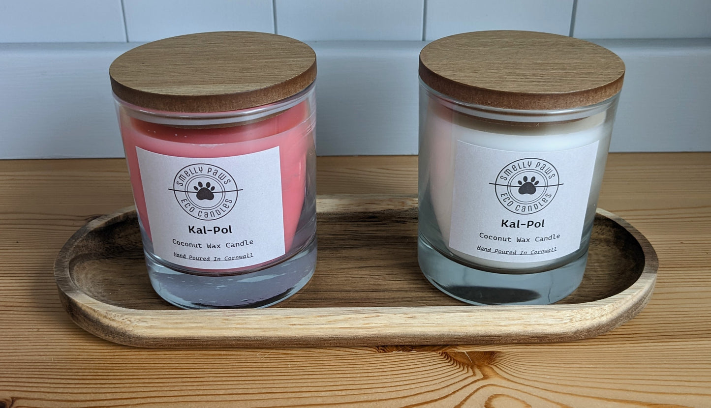 Pink Cal-Pol candle with wooden lid on left with White Cal-Pol candle with wooden lid on right sat on a wooden tray 