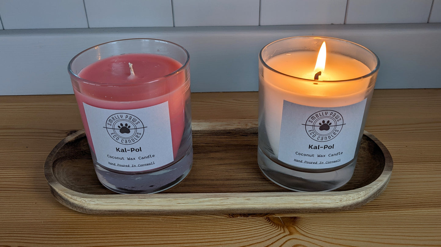 Pink Cal-Pol candle on left with burning  White Cal-Pol candle on right sat on a wooden tray 