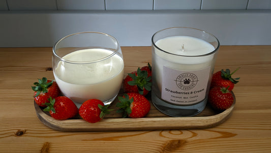 Strawberries and cream candle sat on a wooden tray with a pot of cream and surrounded by Strawberries 